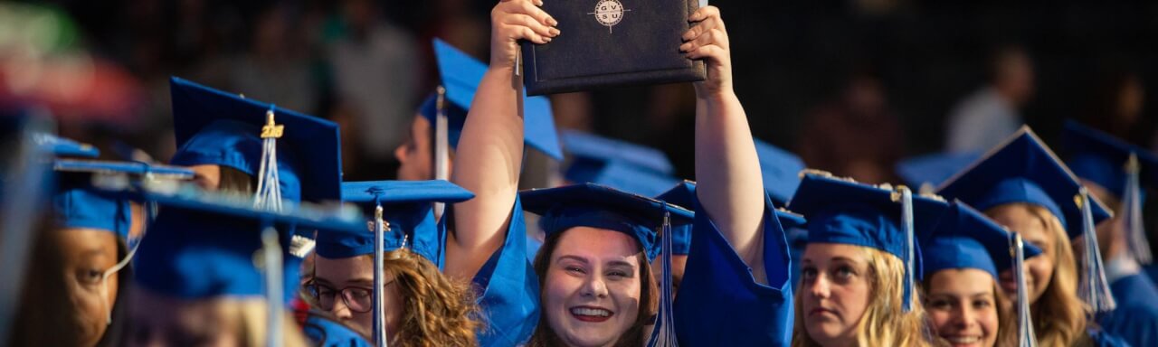 Girl holds up diploma
